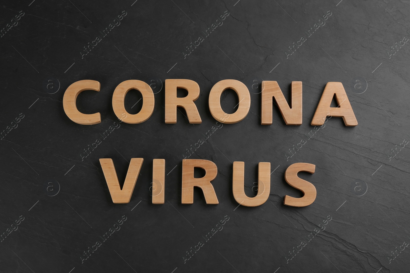 Photo of Words CORONA VIRUS made of wooden letters on black table, top view
