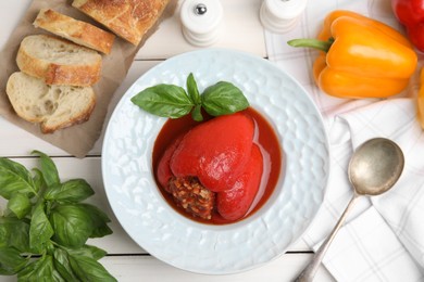 Photo of Delicious stuffed pepper served on white wooden table, flat lay