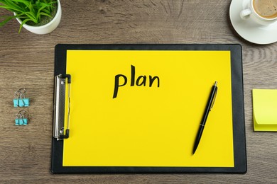 Paper with word Plan, pen, binder clips, coffee and houseplant on wooden table, flat lay