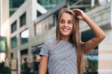 Portrait of beautiful young woman on city street