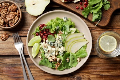 Fresh salad with pear on wooden table, flat lay