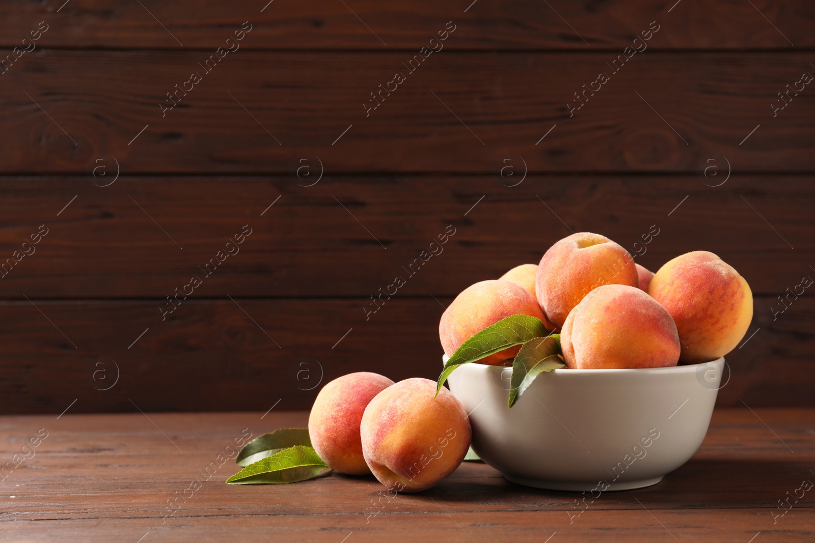 Photo of Plate with fresh sweet peaches on wooden table