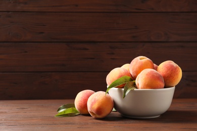 Photo of Plate with fresh sweet peaches on wooden table