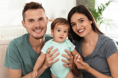 Photo of Happy family with adorable little baby at home
