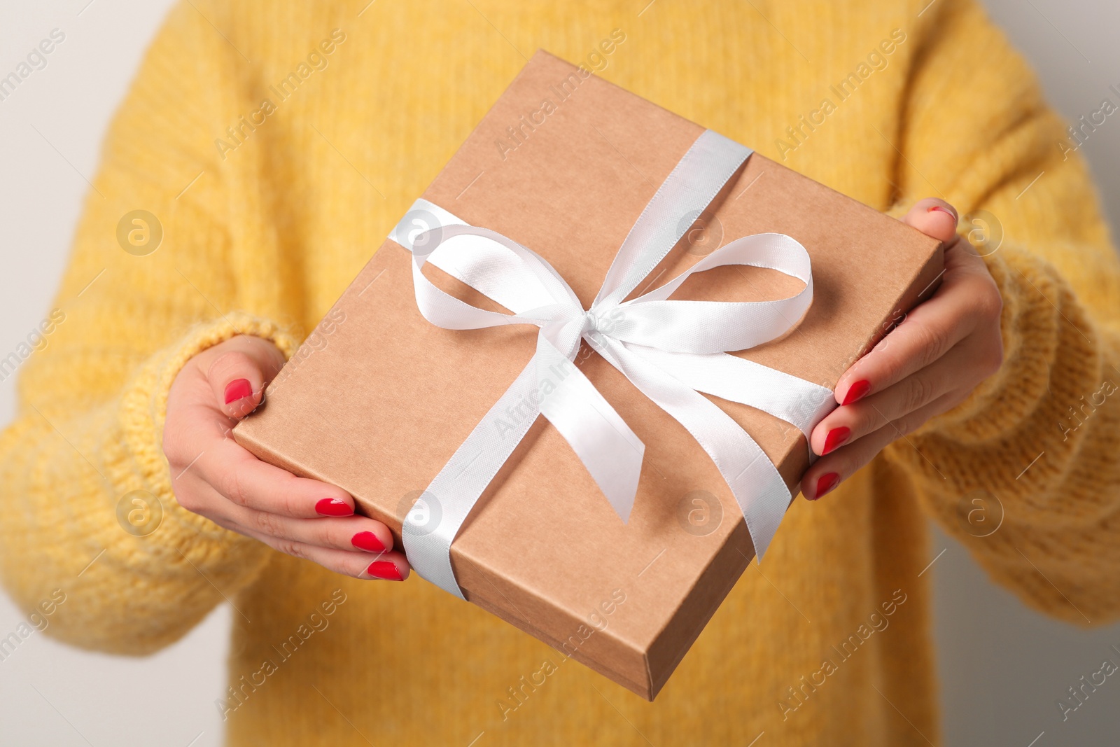 Photo of Christmas present. Woman holding gift box, closeup