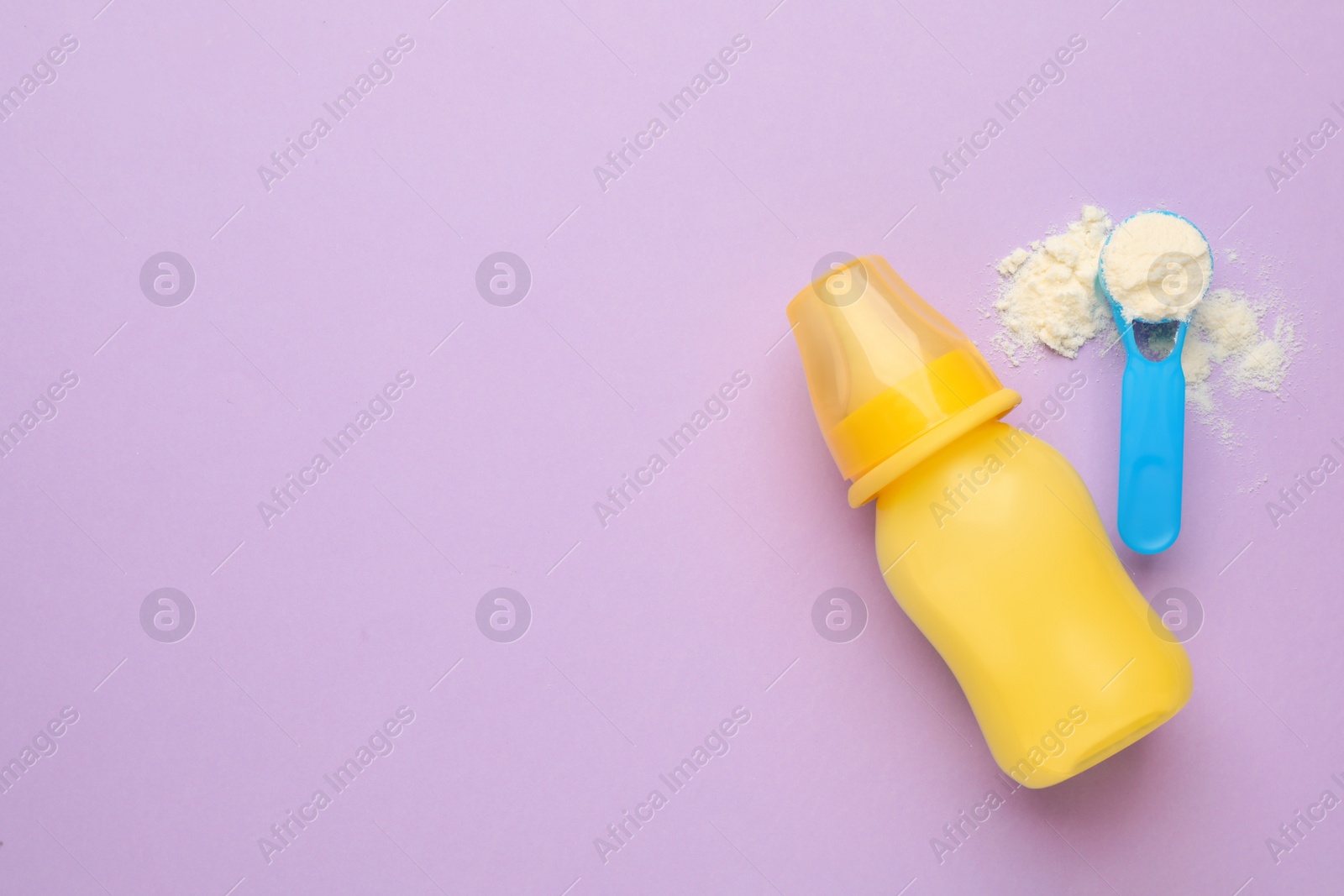 Photo of Feeding bottle with infant formula and powder on violet background, flat lay. Space for text