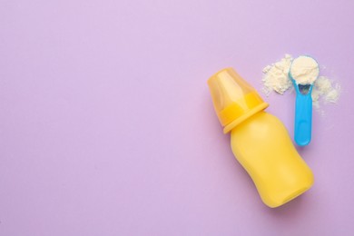 Photo of Feeding bottle with infant formula and powder on violet background, flat lay. Space for text