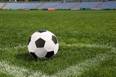 Photo of Football ball on green field grass in stadium