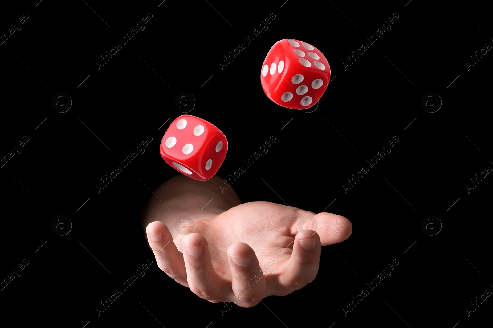 Image of Man throwing red dice on black background, closeup