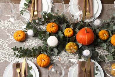 Beautiful autumn table setting. Plates, cutlery, glasses, pumpkins and floral decor, flat lay