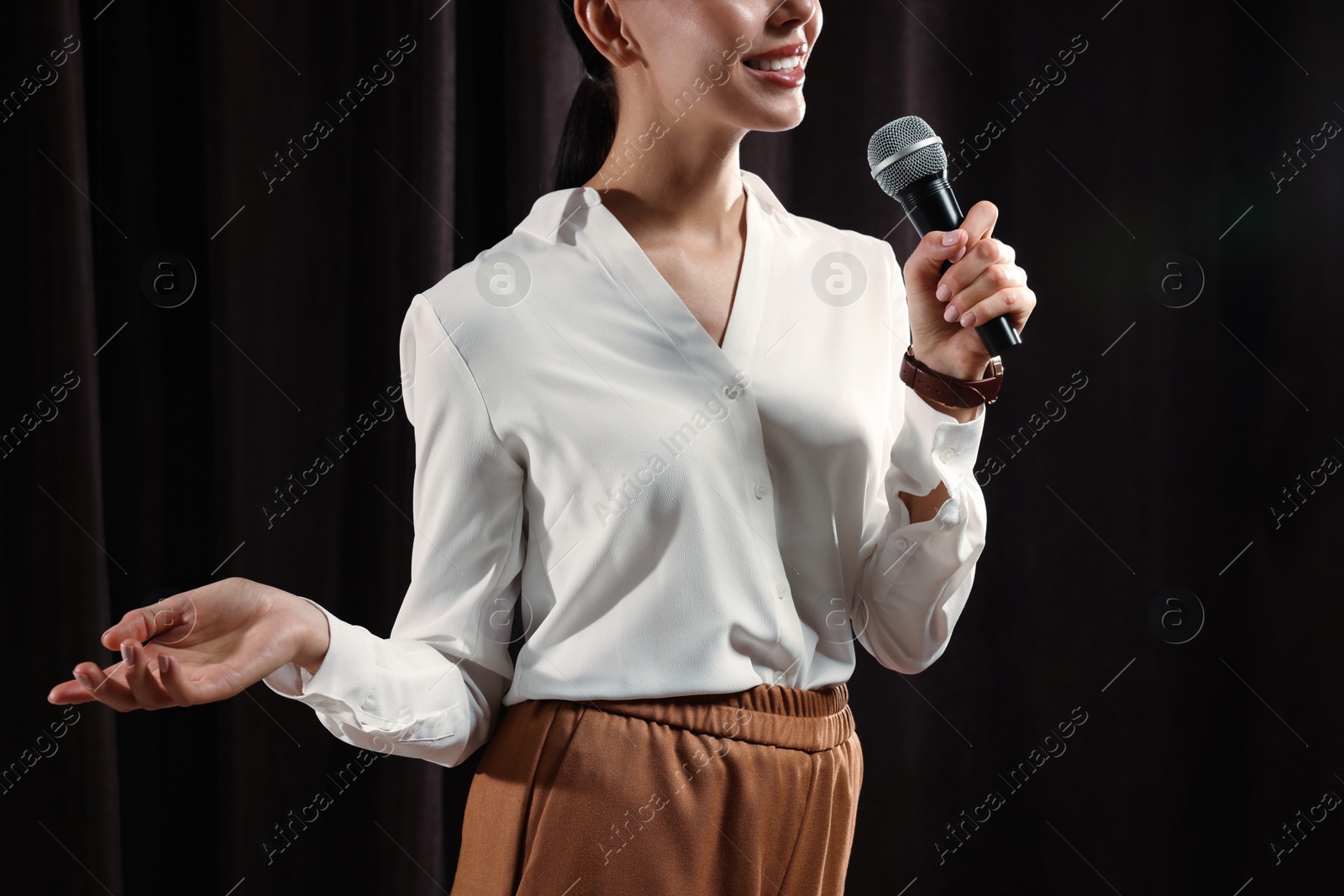 Photo of Motivational speaker with microphone performing on stage, closeup 