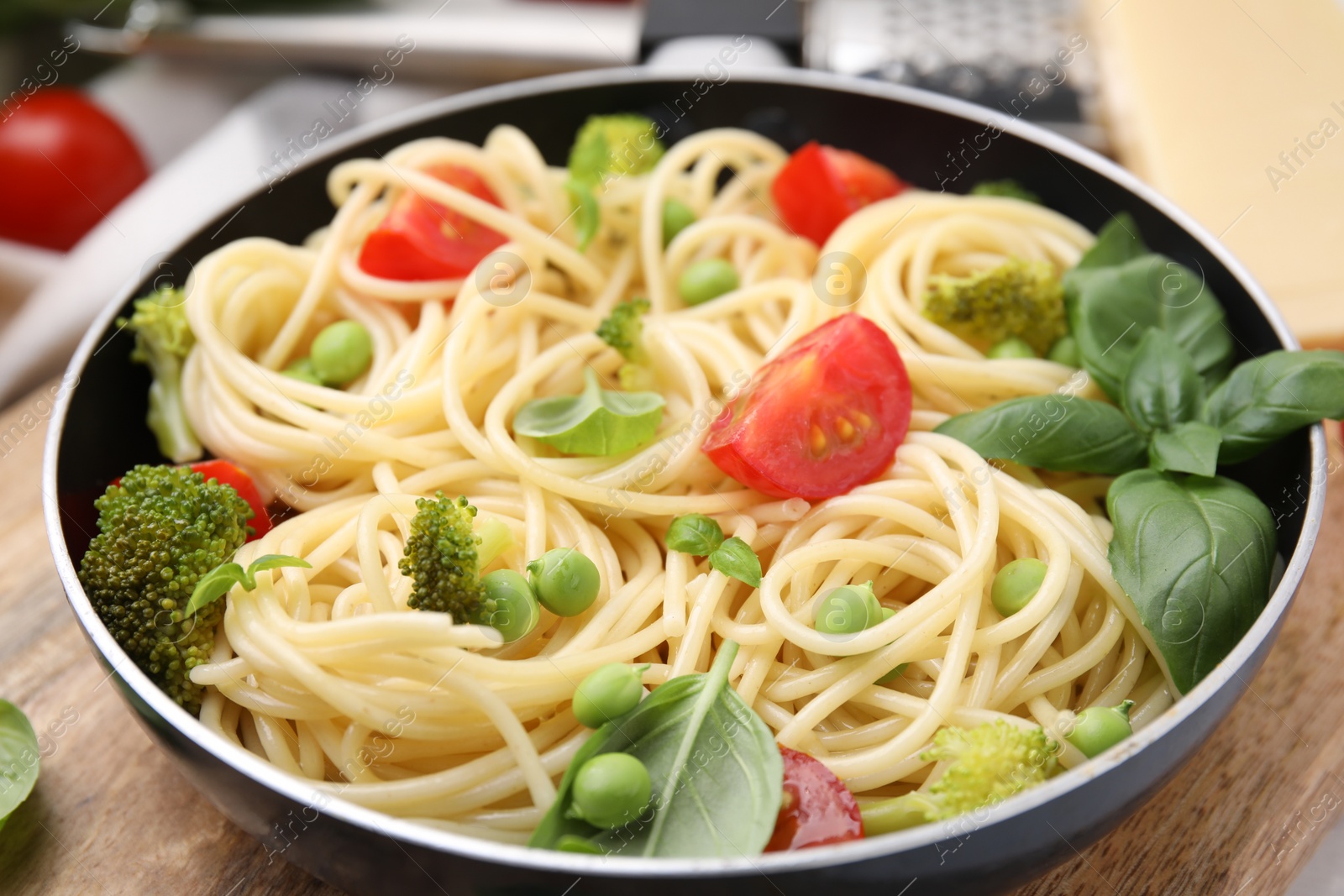 Photo of Delicious pasta primavera in frying pan on table, closeup