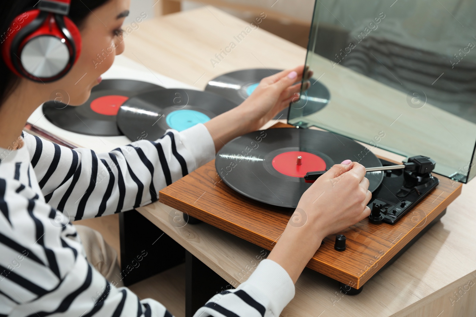 Photo of Woman listening to music with turntable at home