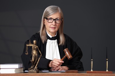 Photo of Judge striking mallet at wooden table indoors