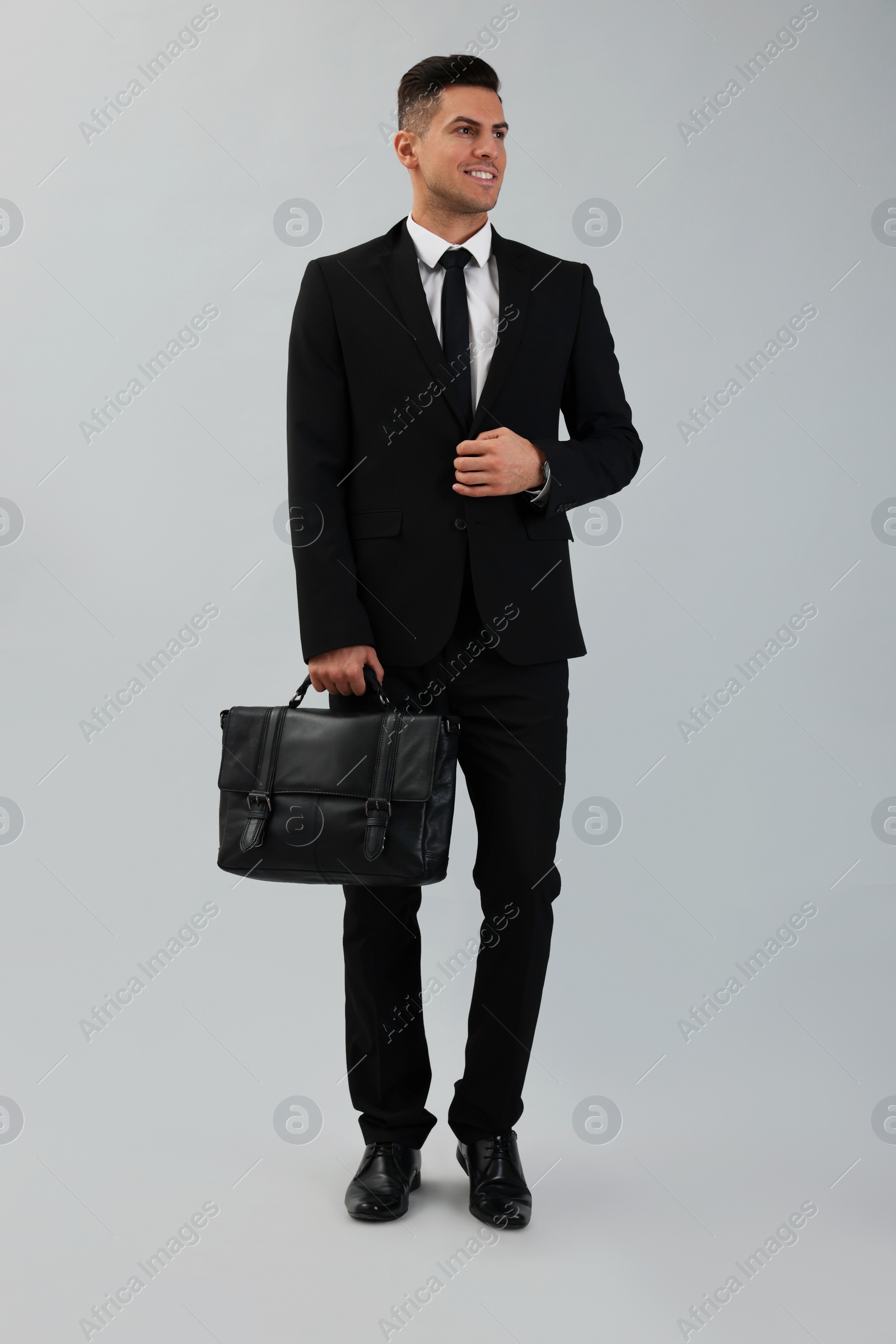 Photo of Businessman with stylish leather briefcase on light background