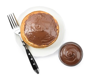 Tasty pancakes with chocolate paste and fork isolated on white, top view