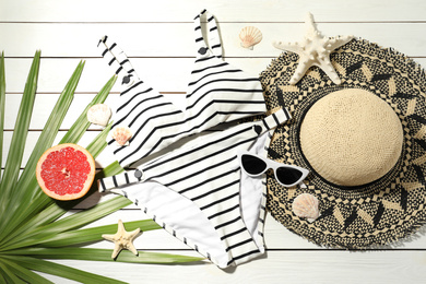Flat lay composition with grapefruit and beach objects on white wooden background