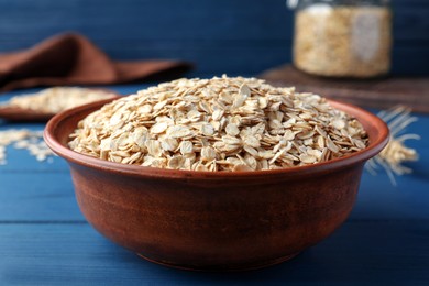 Photo of Bowl of oatmeal on blue wooden table, closeup