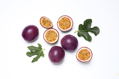 Fresh ripe passion fruits (maracuyas) with leaves on white background, flat lay