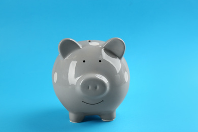 Photo of Cute grey piggy bank on blue background