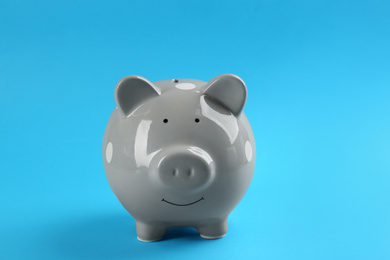 Cute grey piggy bank on blue background