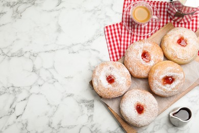 Photo of Delicious jam donuts served with coffee on white marble table, flat lay. Space for text