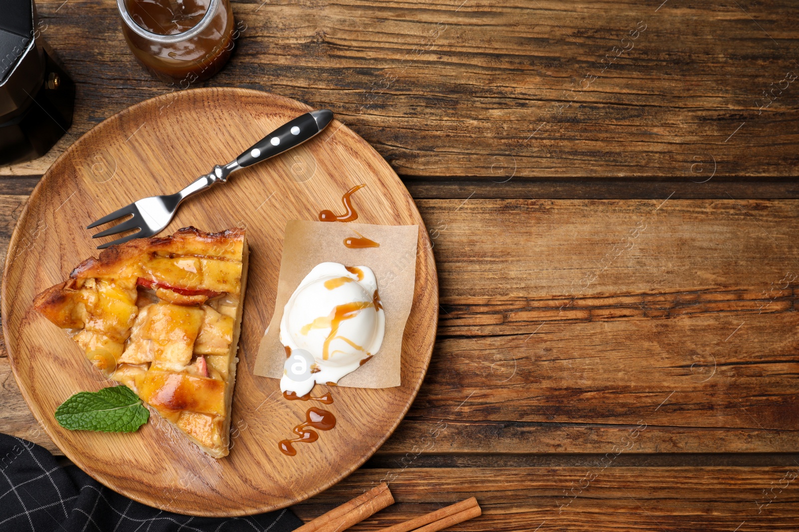Photo of Slice of traditional apple pie with ice cream and mint on wooden table, flat lay. Space for text