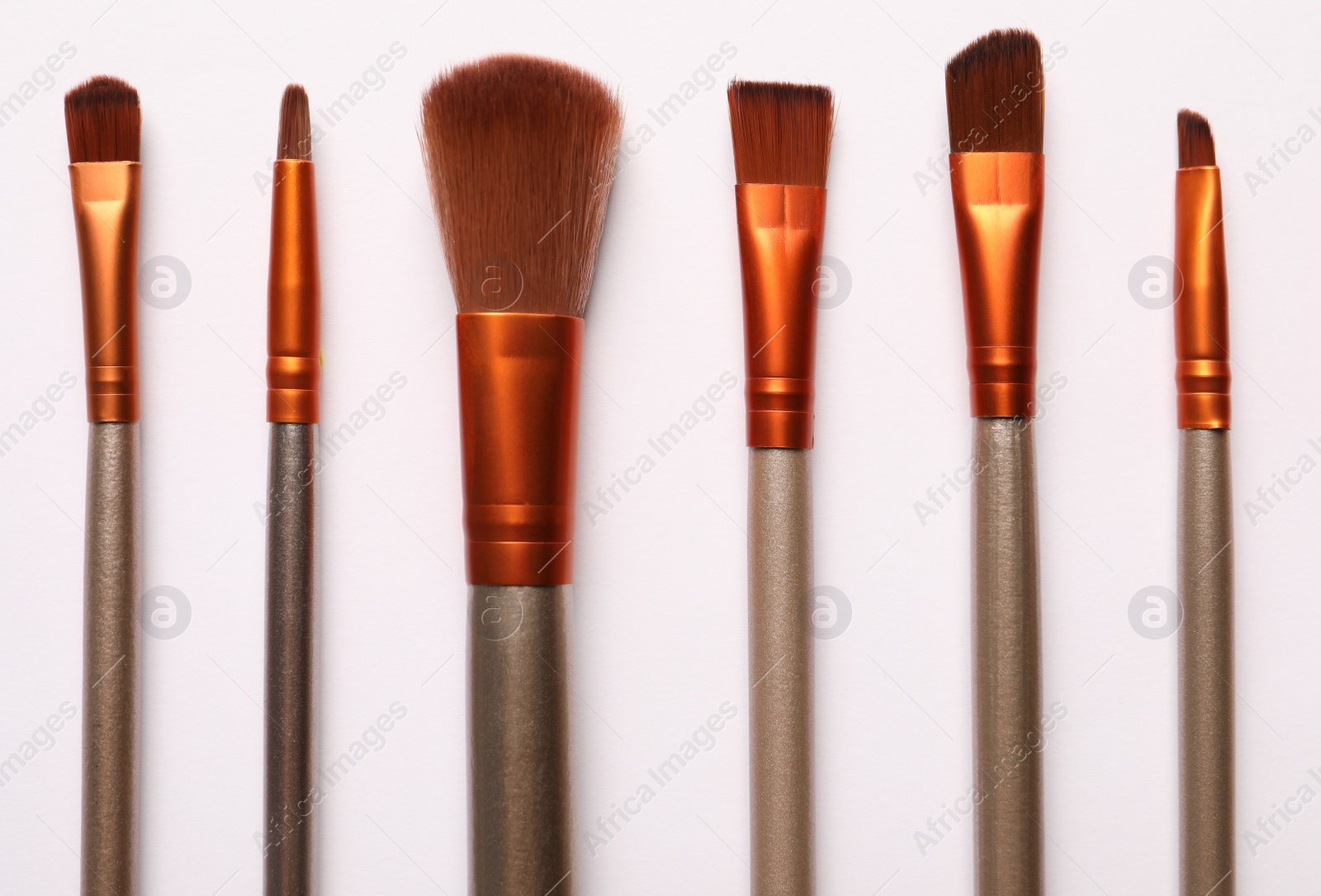 Photo of Different makeup brushes on white background, flat lay