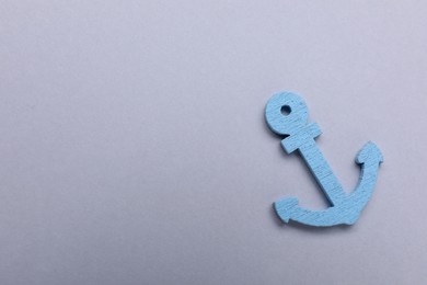 Photo of Anchor figure on light grey background, top view. Space for text