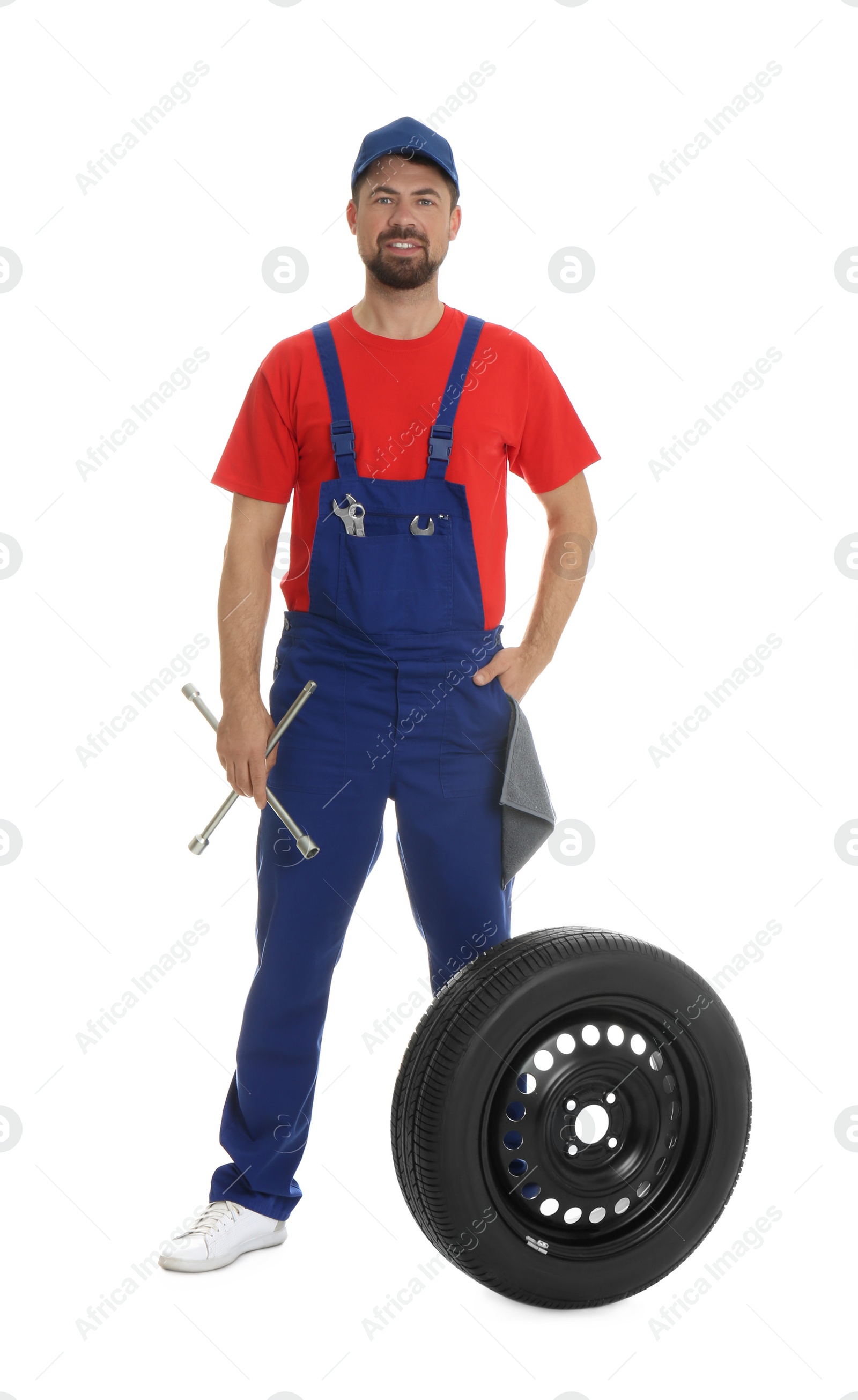 Photo of Full length portrait of professional auto mechanic with lug wrench and wheel on white background