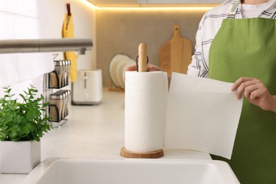 Photo of Woman using paper towels in kitchen, closeup