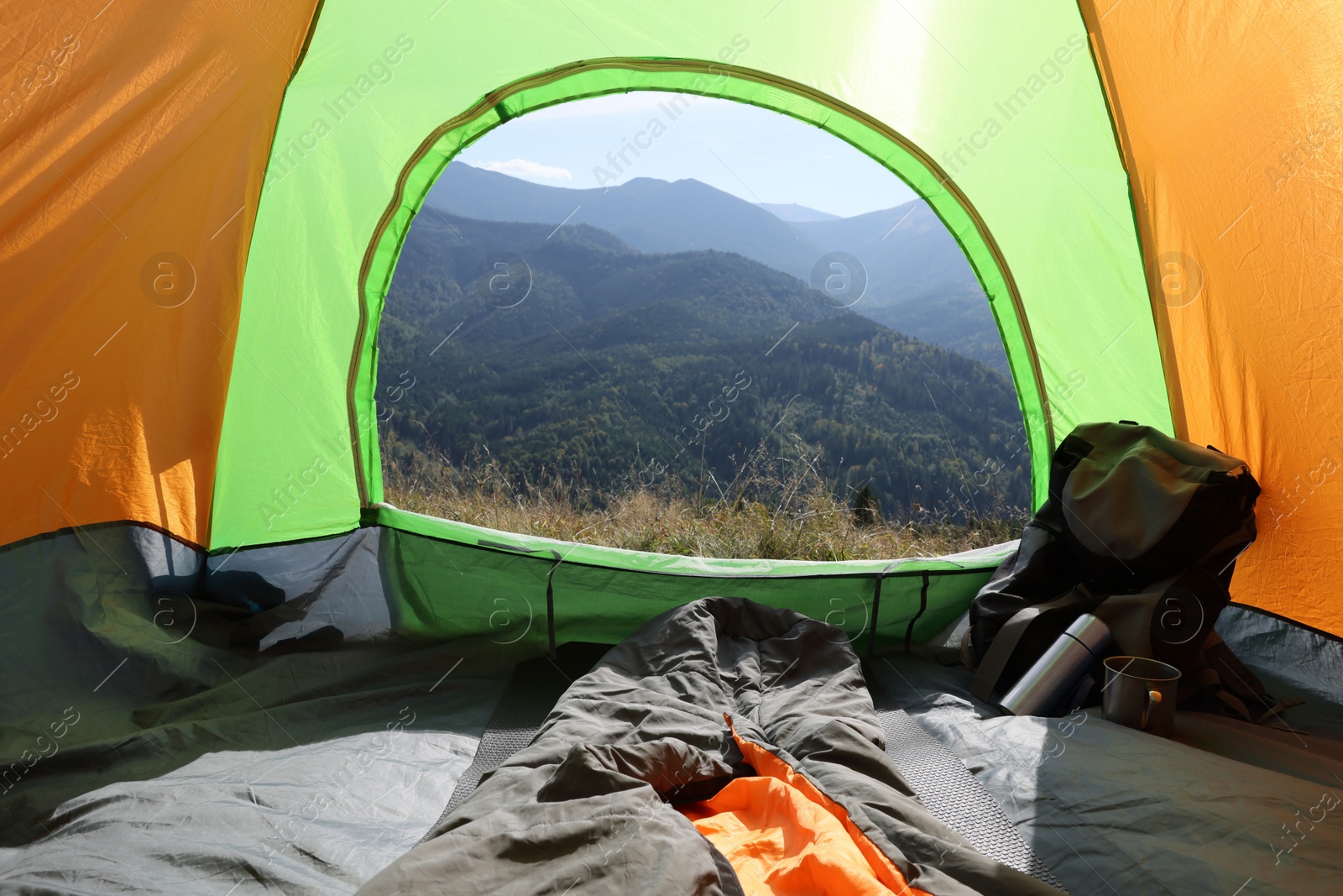 Photo of Camping tent with sleeping bag in mountains, view from inside