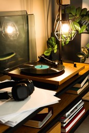 Photo of Stylish turntable with vinyl record on table indoors