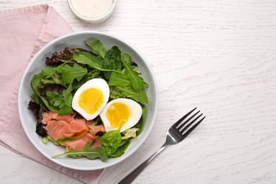 Delicious salad with boiled egg, salmon and arugula served on white wooden table, flat lay. Space for text