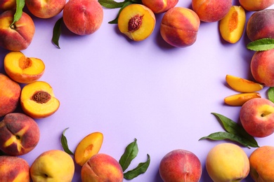 Frame of fresh ripe peaches and green leaves on violet background, flat lay. Space for text