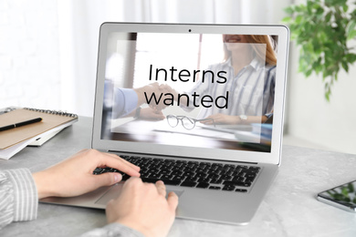 Image of Woman with laptop at marble table, closeup. Interns wanted