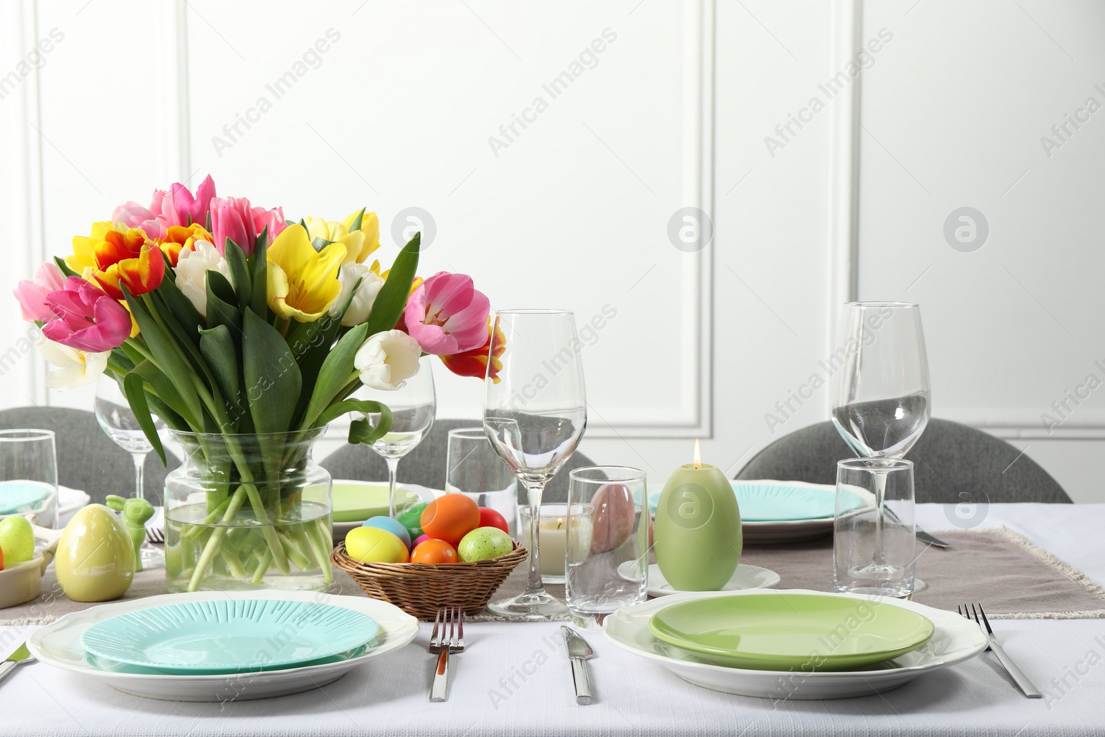 Photo of Easter celebration. Festive table setting with beautiful flowers and painted eggs