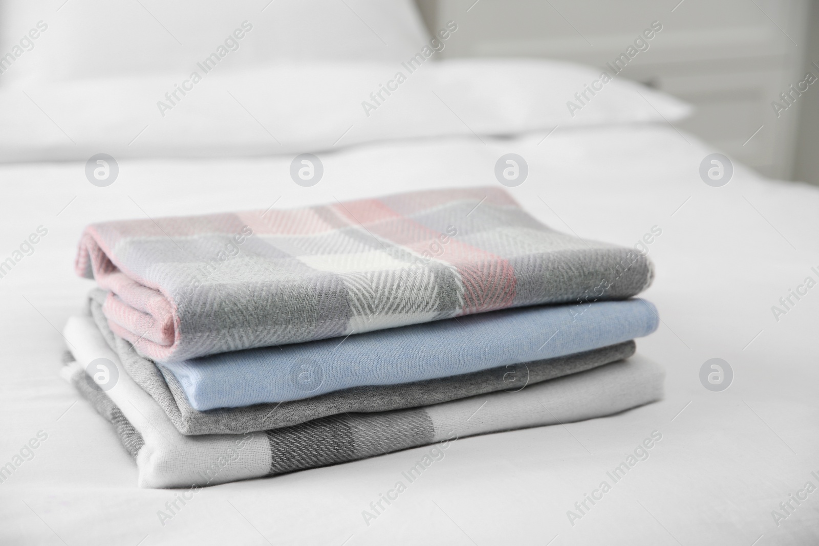 Photo of Stack of folded cashmere clothes on bed