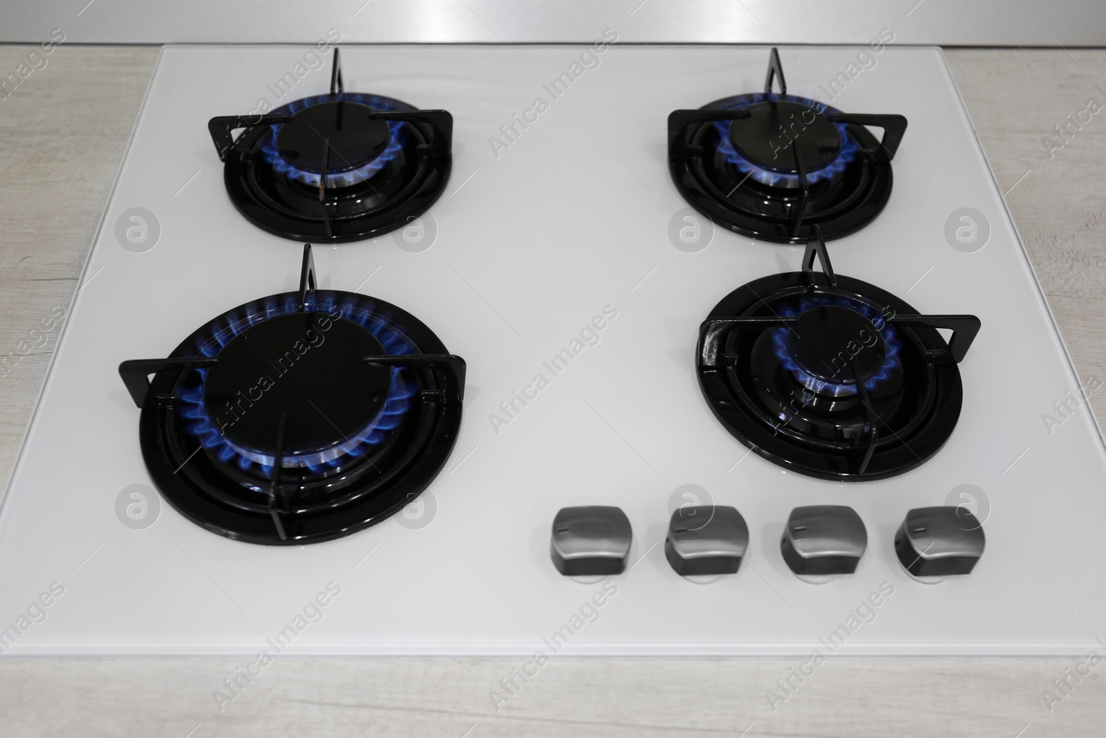 Photo of Modern kitchen stove with burning gas, above view