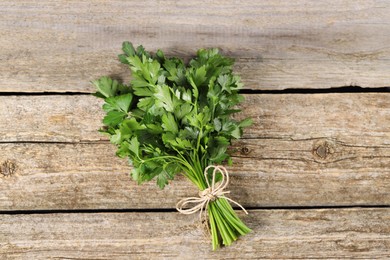 Photo of Bunch of fresh green parsley leaves on wooden table, top view