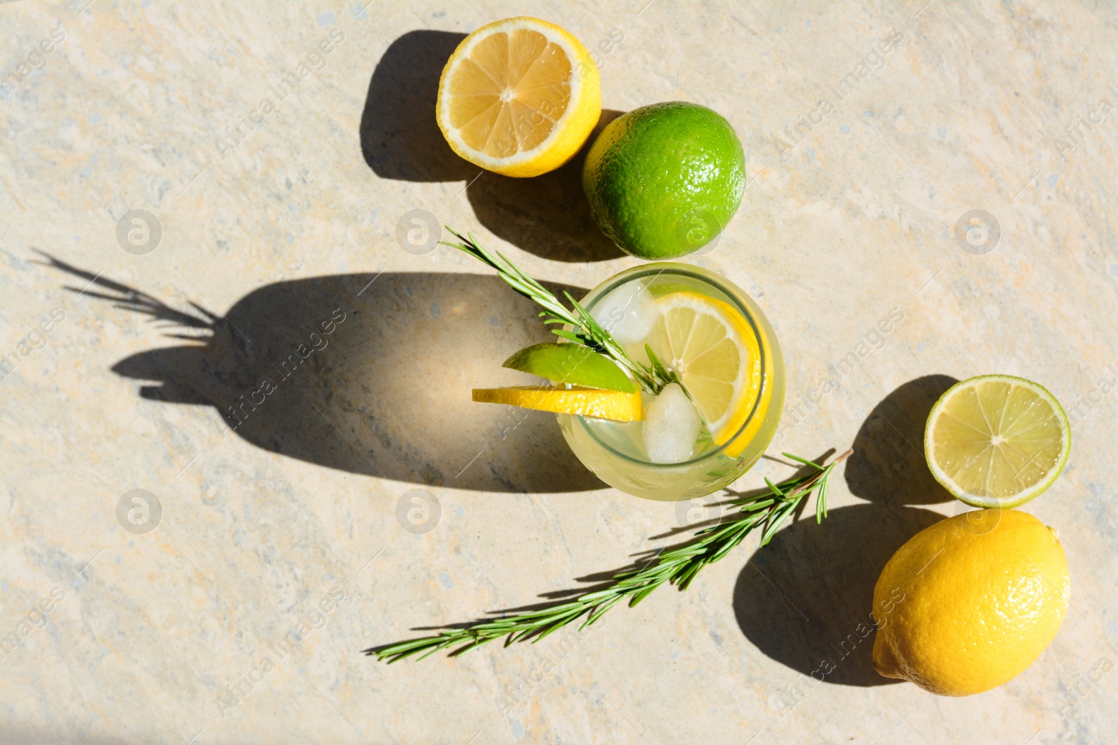 Photo of Summer refreshing lemonade and ingredients on light grey table, flat lay. Space for text