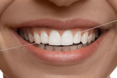 Photo of Woman flossing his teeth, closeup. Dental care
