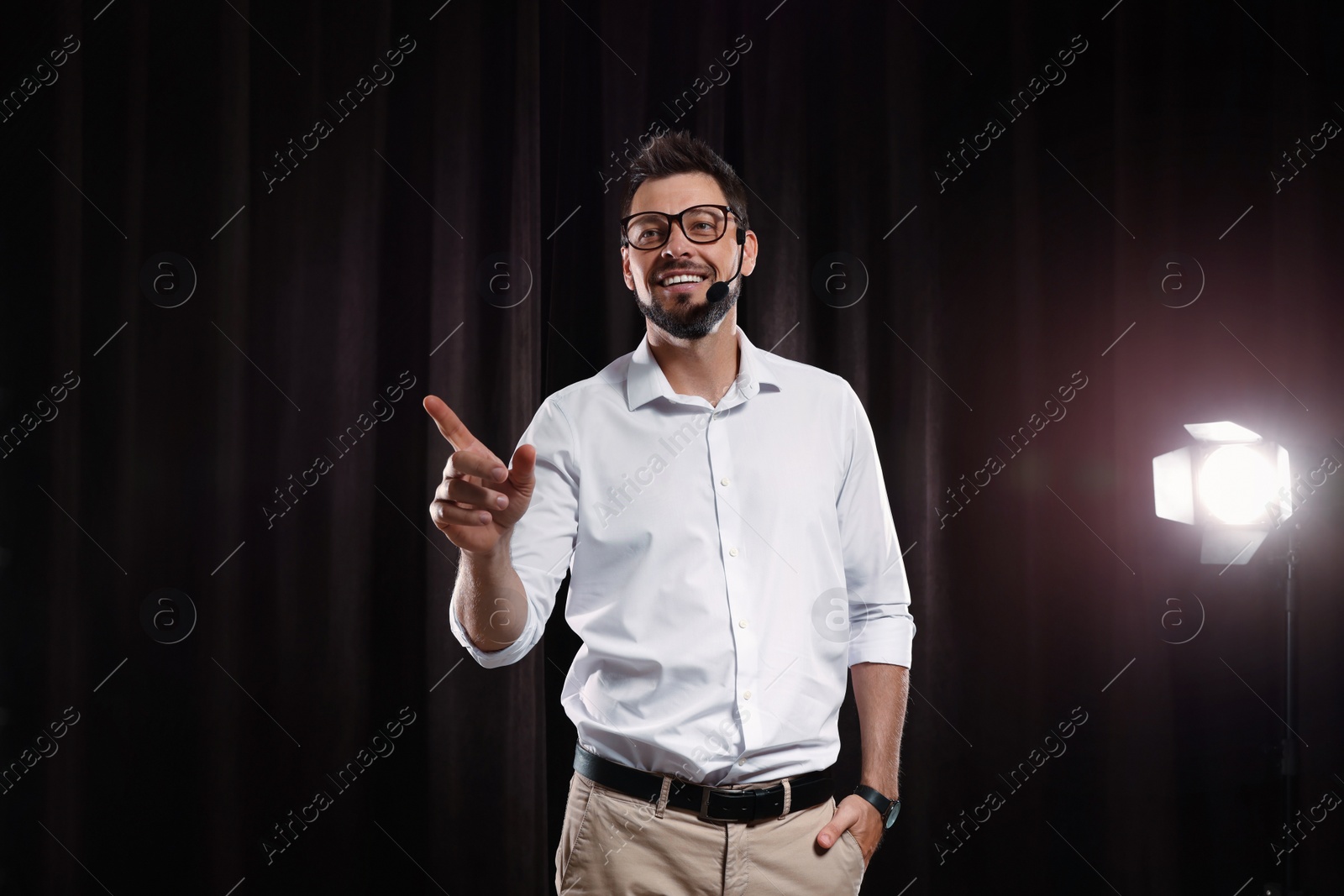 Photo of Motivational speaker with headset performing on stage