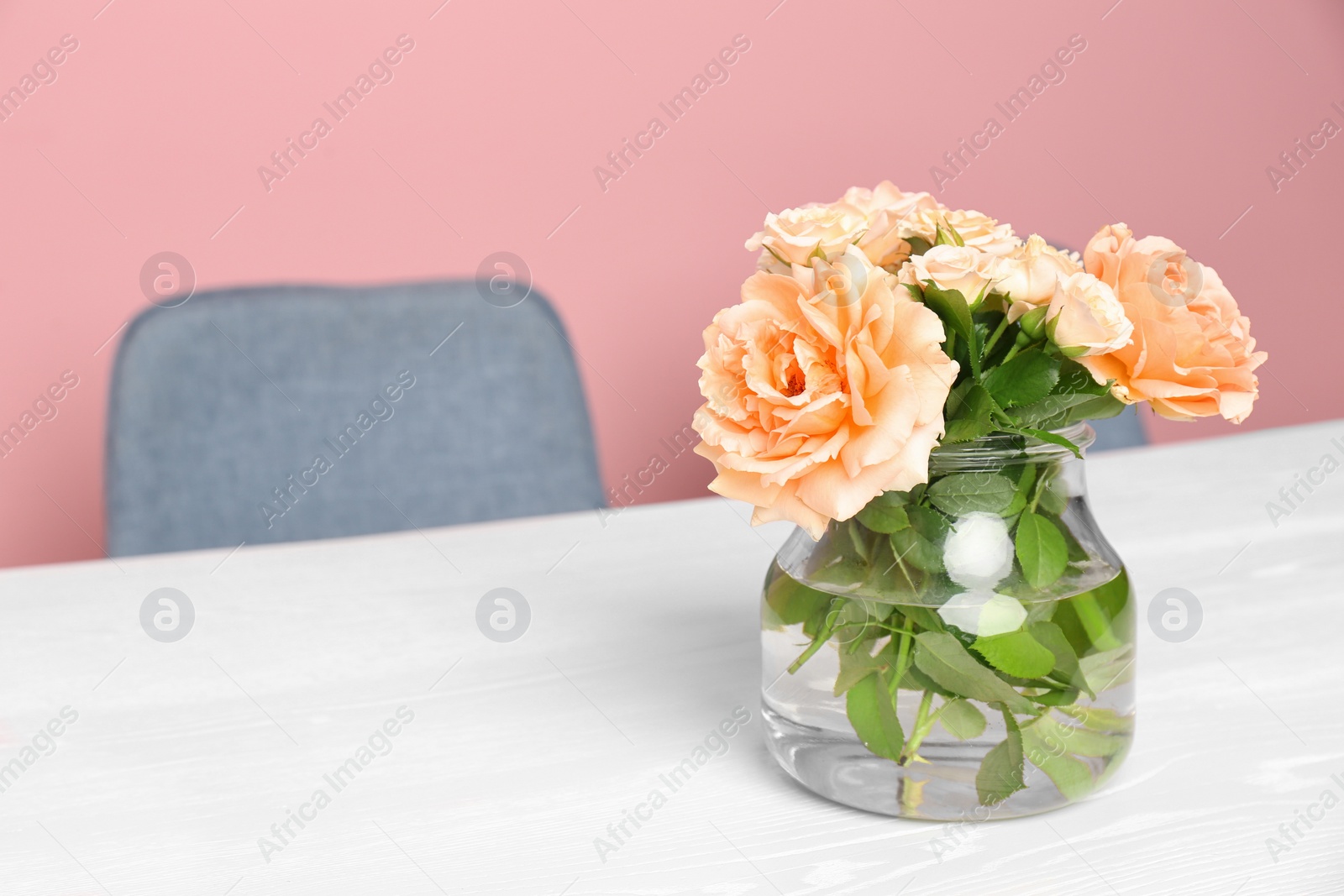 Photo of Vase with blooming flowers on table indoors