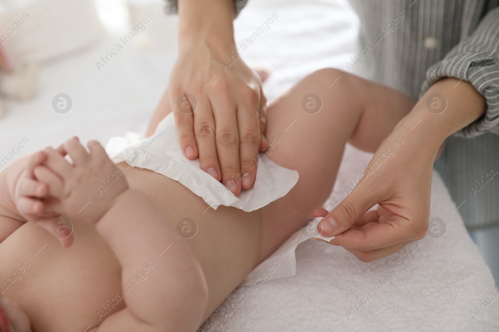 Photo of Mother changing her baby's diaper on table, closeup