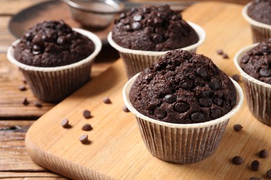 Tasty chocolate muffins on wooden table, closeup