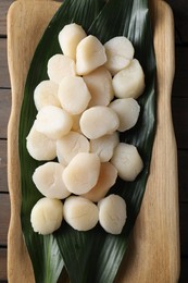 Photo of Fresh raw scallops on wooden table, top view