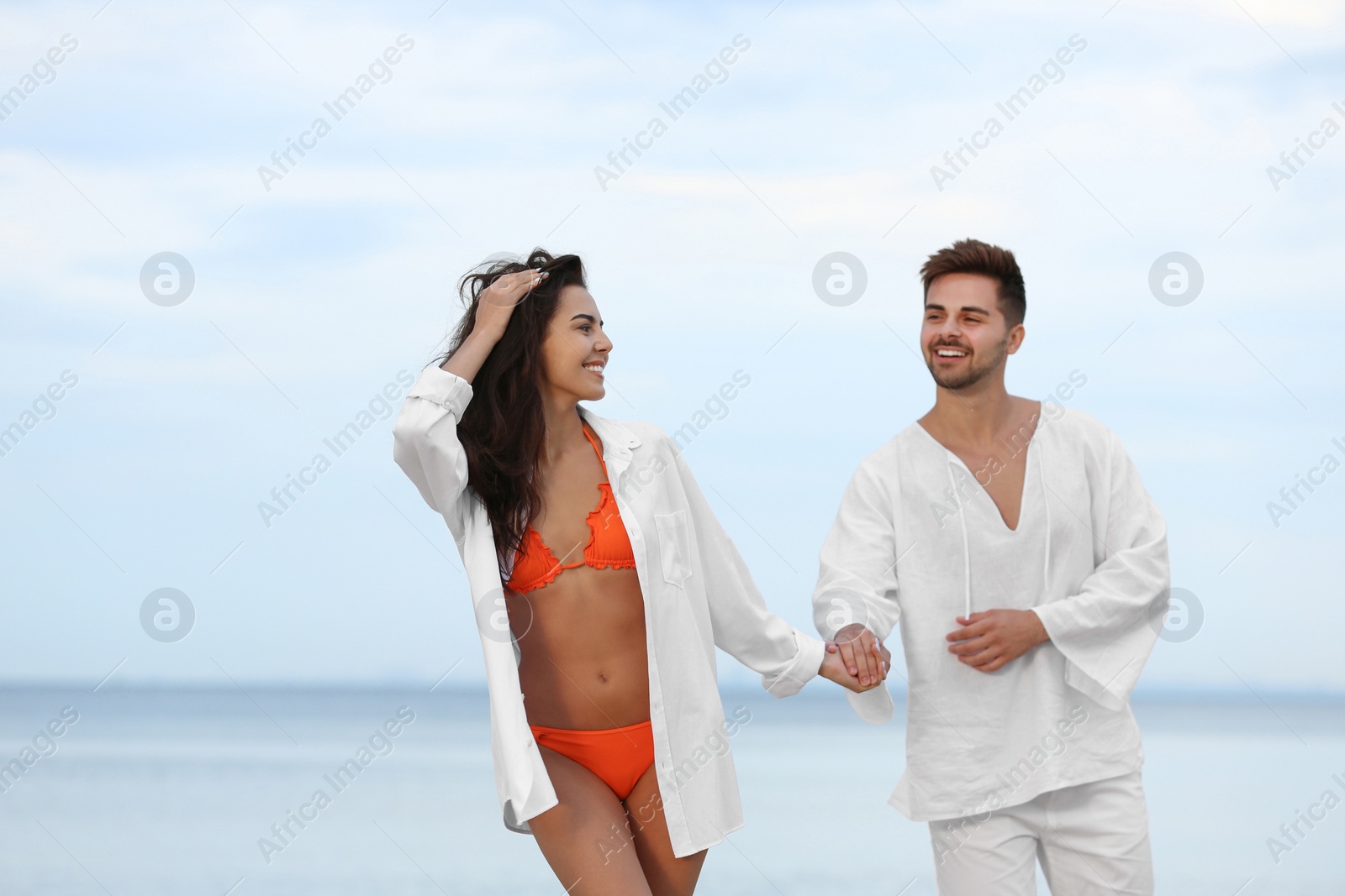 Photo of Happy young couple walking together on beach