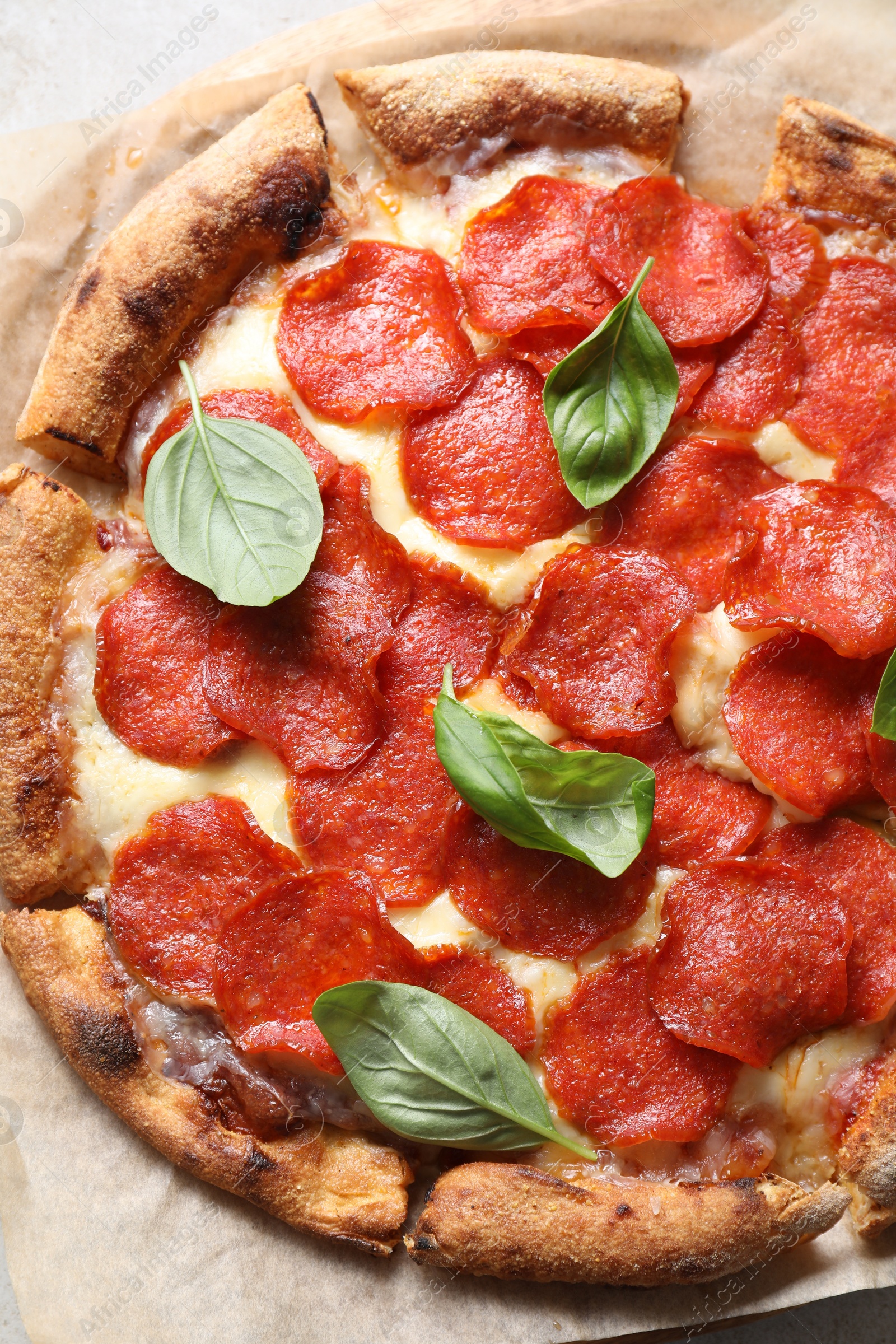 Photo of Tasty pepperoni pizza with basil on table, top view