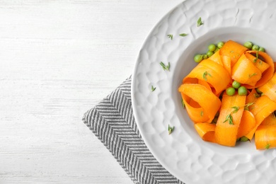 Tasty salad with fresh carrot in plate on table, top view